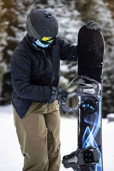 Mladá dívka snowboardista čištění její snowboard — Stock fotografie