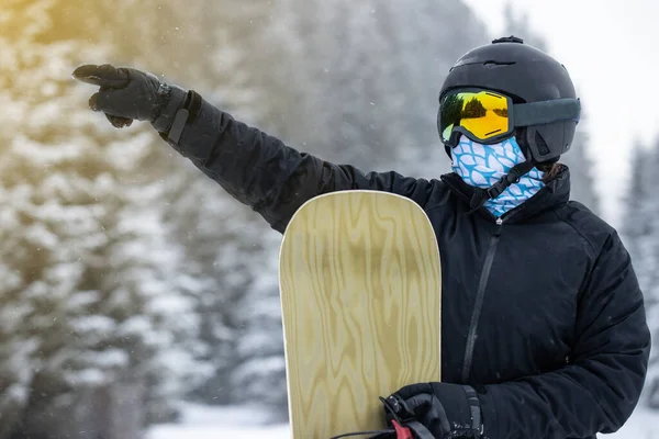 Snowboard 'cu kız elinde kaykayıyla bir şey gösteriyor..