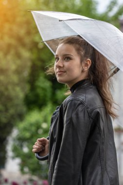 Yağmurda şemsiye tutan genç bir kız. Sokaktaki kız..