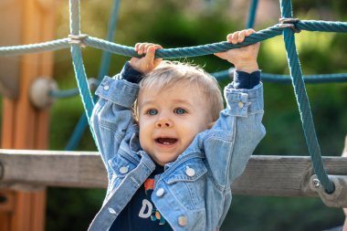 Parkta oynayan küçük sarı saçlı çocuk. Mutlu çocuk..