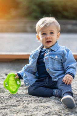 Parkta oynayan küçük sarı saçlı çocuk. Mutlu çocuk..