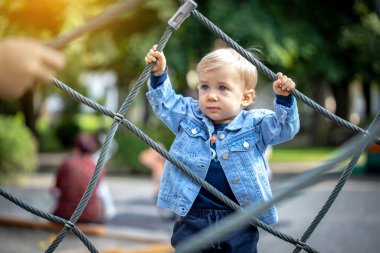 Parkta oynayan küçük sarı saçlı çocuk. Mutlu çocuk..