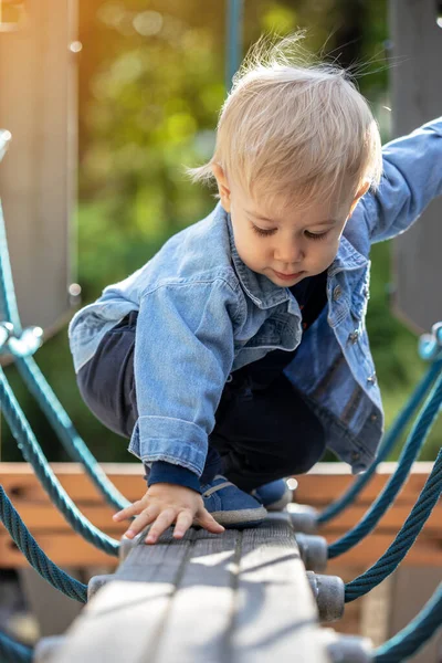 Parkta oynayan küçük sarı saçlı çocuk. Mutlu çocuk..