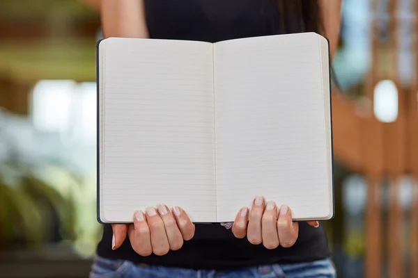 Young caucasian woman holding and showing book — Stock Photo, Image