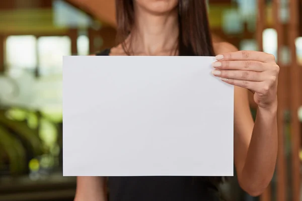 Молода біла жінка тримає білий аркуш паперу — стокове фото