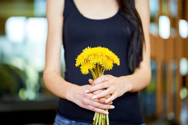Dandelions bir sürü tutan genç beyaz kadın