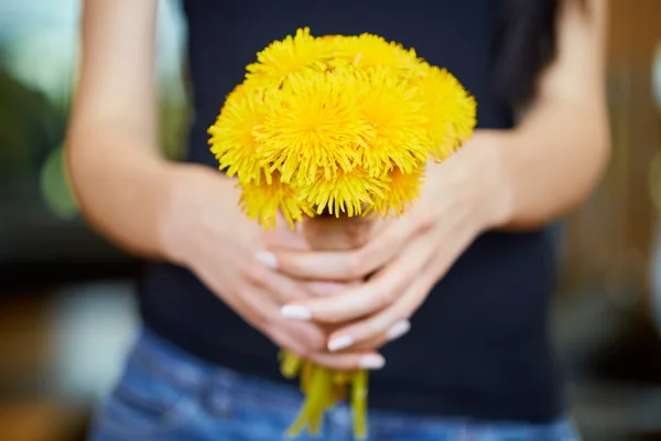 Dandelions bir sürü tutan genç beyaz kadın