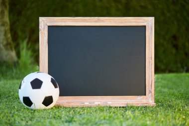 Futbol ve yazı tahtası üzerinde çim sahası