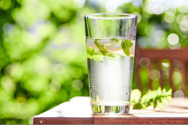 Cool drink with mint and ice on table