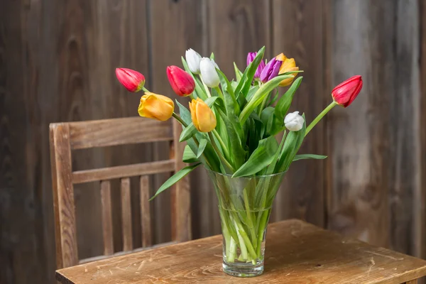 Coloful tulipány ve váze na dřevěný stůl — Stock fotografie