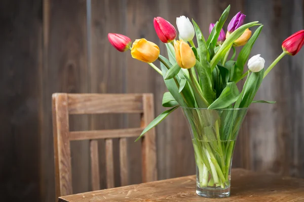 Coloful tulipány ve váze na dřevěný stůl — Stock fotografie