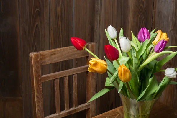 Coloful tulipány ve váze na dřevěný stůl — Stock fotografie