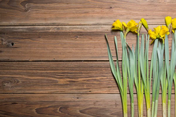 Narcisy na dřevěný stůl — Stock fotografie