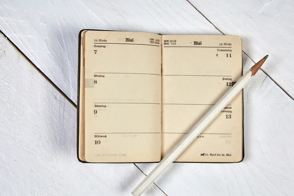 Old calendar and white pencil on a white table — Stock Photo, Image