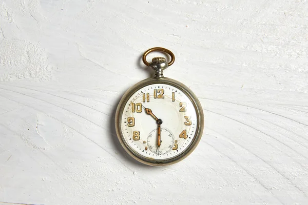 Beyaz ahşap bir masa üzerinde eski cep saati — Stok fotoğraf