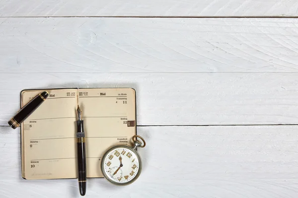 Antique fountain pen, old calendar and watch on a white wooden t — Stock Photo, Image