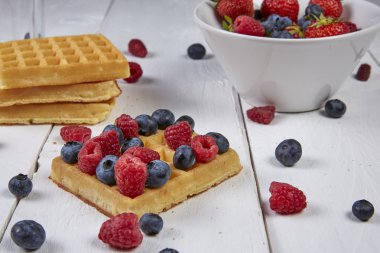 Meyveler bir gözleme ve Beyaz ahşap bir masa üzerinde bir kasede