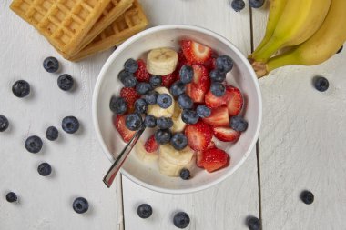 Meyveler bir gözleme ve Beyaz ahşap bir masa üzerinde bir kasede