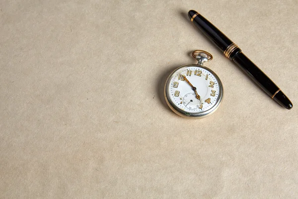Old pocket watch on old paper — Stok fotoğraf