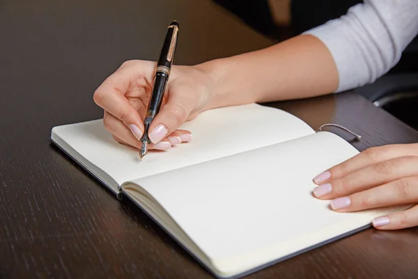 Mulher escrevendo em um livro com caneta — Fotografia de Stock