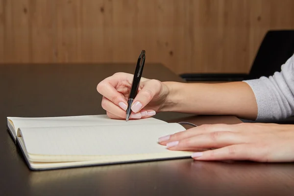 Woman writing in a book with pen — Stock Photo, Image