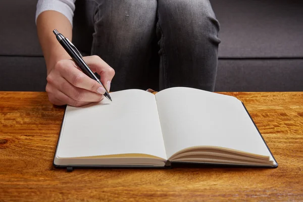 Woman writing in a book with pen — Stock Photo, Image