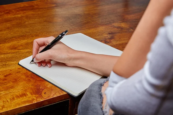 Woman writing in a book with pen — Stock Photo, Image