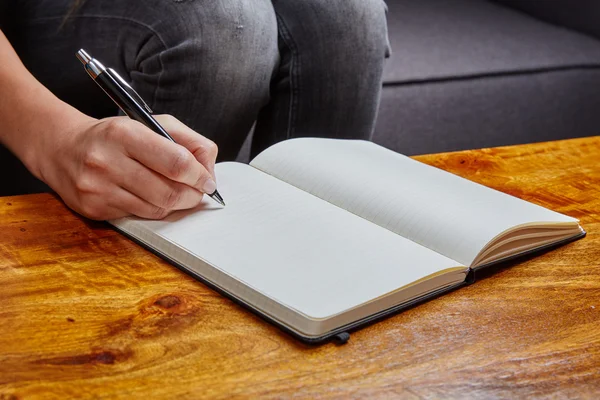 Mujer escribiendo en un libro con pluma — Foto de Stock