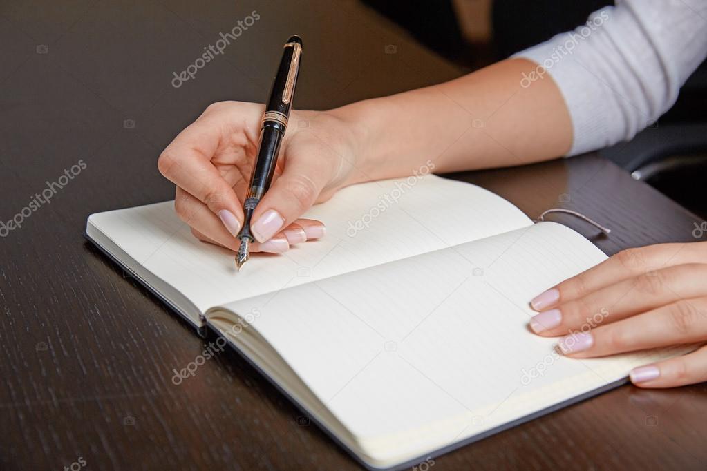 Woman writing in a book with pen