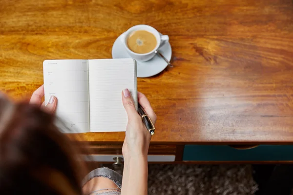 Woman writing in notebook — Stock Photo, Image