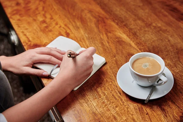 Woman writing in notebook — Stock Photo, Image