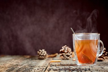 Çam kozalakları ahşap bir masada sıcak buharlı çay