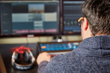 Audio engineer sitting in front of a mixing desk