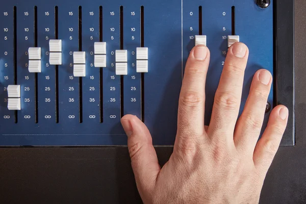 Fingers of audio engineer pushing the faders of an auio mixer — ストック写真