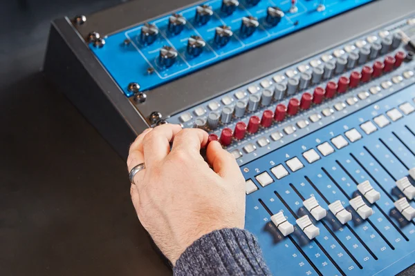 Audio engineer turning the knobs on the mixer — ストック写真