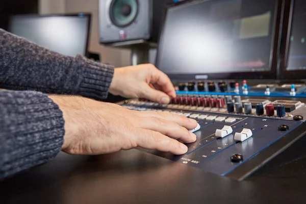 Zijaanzicht van handen van audio ingenieur mengen op console — Stockfoto