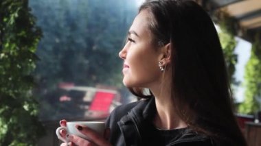 Çok çekici kız bir kahve dükkanı ve gülümsüyor kahve içme. Kız çok güzelmiş.