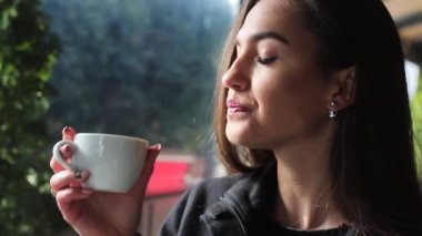 Bir kahve dükkanı ve gülümsüyor kahve içmek çok güzel ve çekici kız.