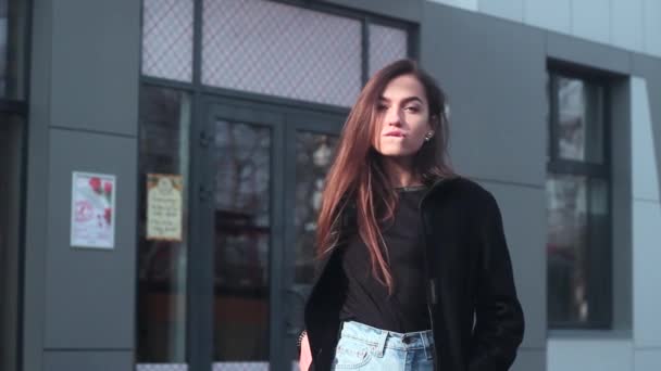 Hermosa chica posando en la cámara. Mujer se para en una calle en el centro de la ciudad . — Vídeos de Stock