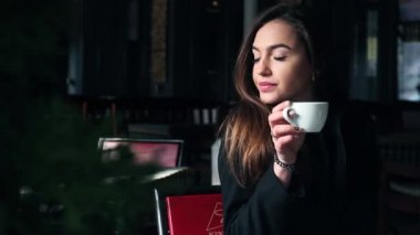 Çok güzel bir kız bir restoranda kahve içme ve gülümseyen.