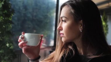 Çok çekici kız bir kahve dükkanı ve gülümsüyor kahve içme. Dumanı tüten Kupası.