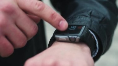 Modern adam akıllı saatler elinde ayarlar. Yakın çekim.