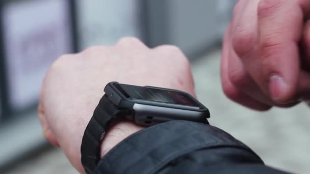 Man Using Smart Watches. he Stands Near the Business Center on the Street. — Stock Video