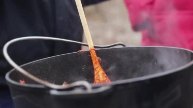 Yanıyor kampta hazırlanan lezzetli çorba. Ahşap bir raket yapışmasını tencere.