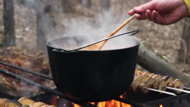 Vaření potravin v kempu venku. Ostatní turisté v lese. — Stock video