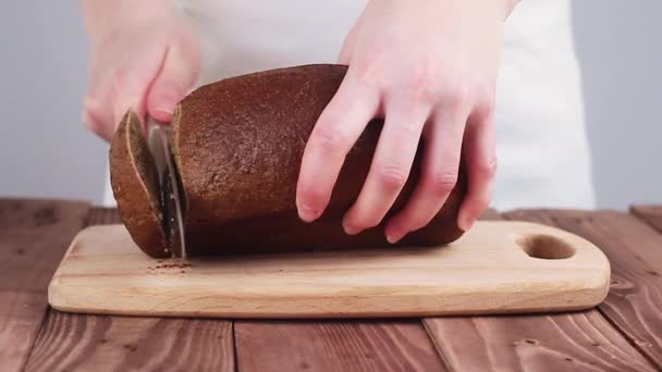 Koch schneidet Schwarzbrot auf dem Brett. die Küche im Restaurant. Zeitlupe. — Stockvideo