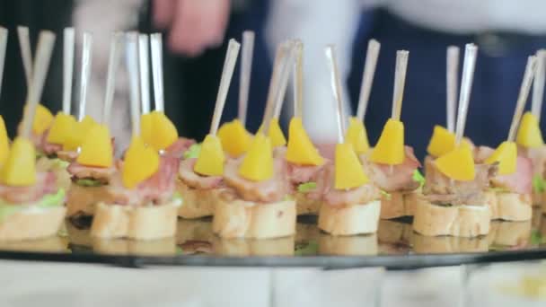 Deliciosos Canapés y Snacks en el Banquete de Bodas. La gente impone comida en el plato . — Vídeos de Stock