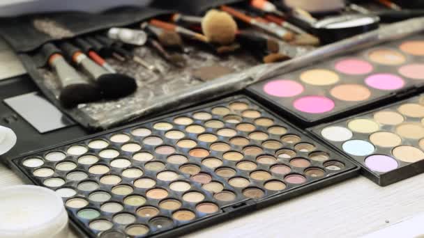 Maquillaje Artista Hacer Maquillaje. sobre la mesa es un cosmético diferente: sombras, ocultador, cepillos . — Vídeos de Stock