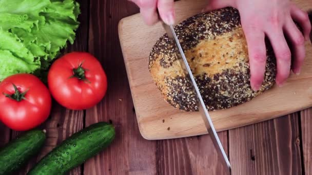 Chef Cuts friss kenyér kés. a táblázat a zöldségek: paradicsom, uborka és saláta. az étterem konyhájáról. Felülnézet — Stock videók