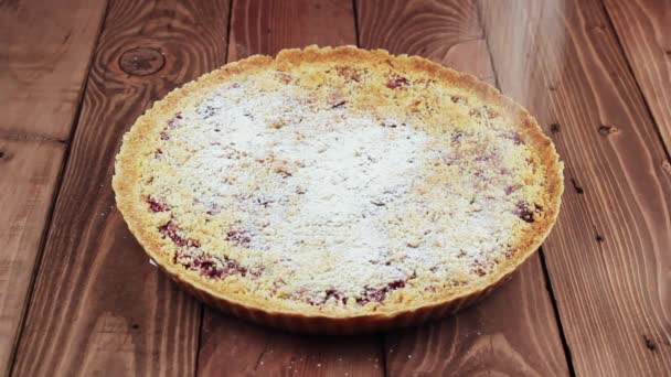 Baker rocía pastel de cereza con azúcar en polvo. La torta es muy hermosa . — Vídeo de stock